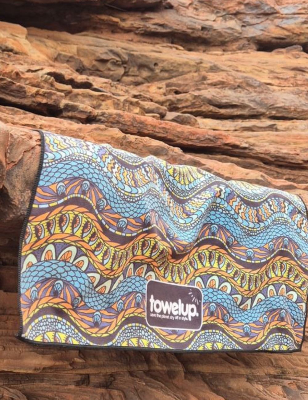 100 A towel thrown over a rock with a dry, scenic trail background