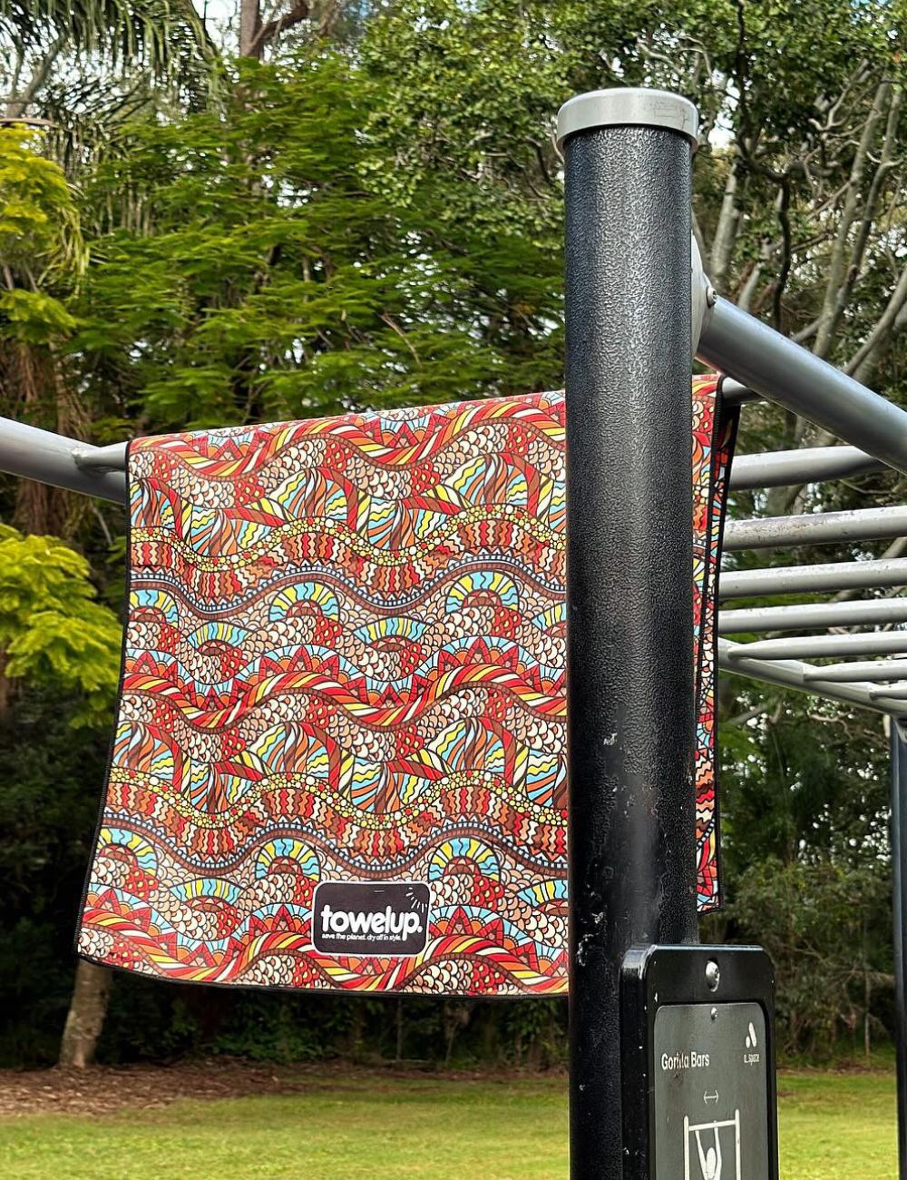 106 A towel thrown over equipment at a park in a scenic green backdrop
