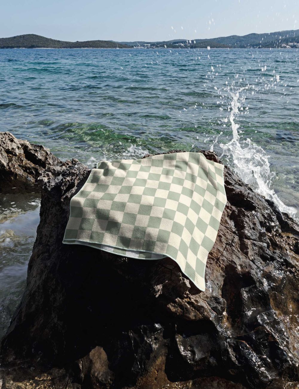 24 Beach towel on a rock by the sea