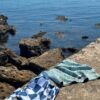 Beach towel on a rock by the sea