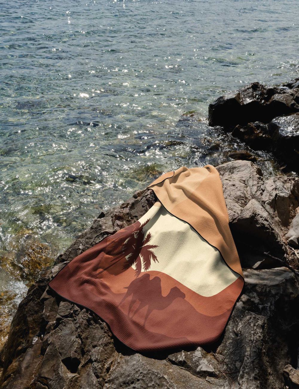 47 Beach towel on a rock by the sea