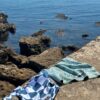 Beach towel on a rock by the sea